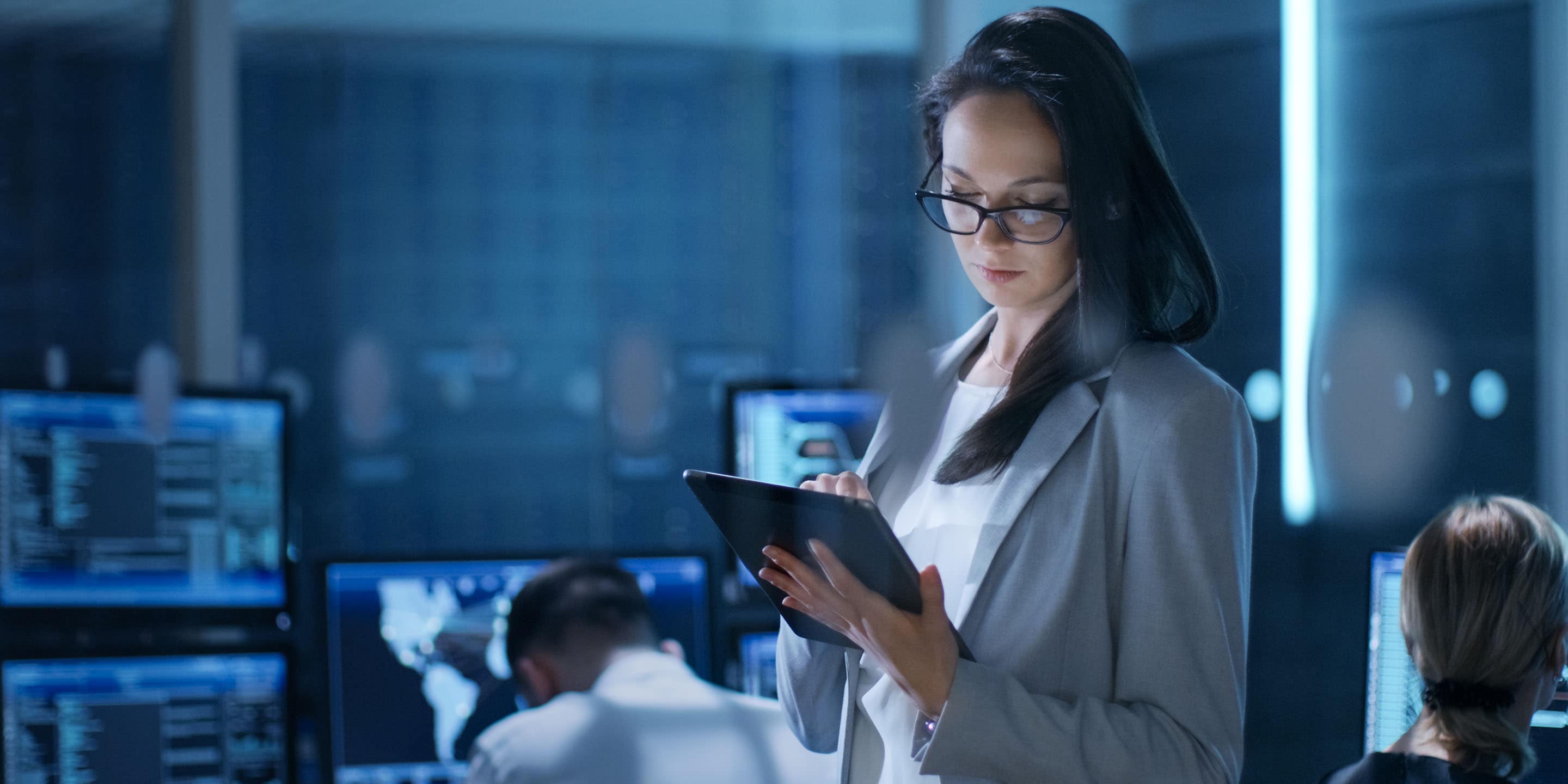 Young Female Engineer Uses Tablet in System Control Center